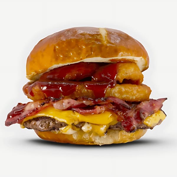 Blazin’ Grill burger with bacon, melted cheese, onion rings, and barbecue sauce on a pretzel bun.