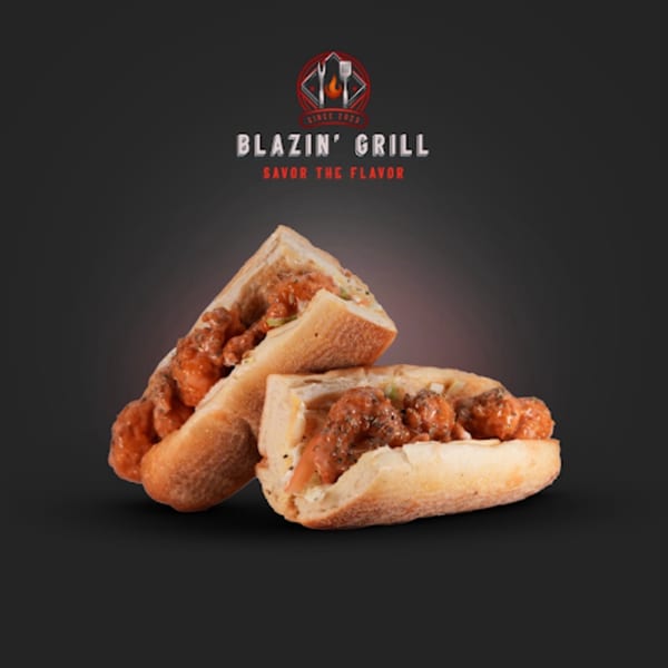 Two halves of a Blazin' Grill sub sandwich filled with saucy meatballs and spices.